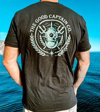 Load image into Gallery viewer, The Emblem print in turquoise and gold on a black shirt
